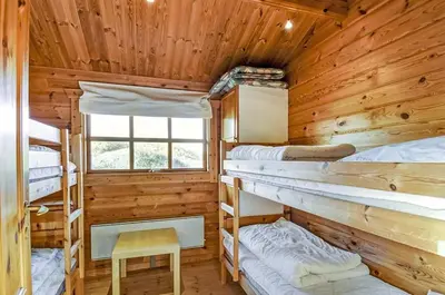 a cabin with four bunk beds and a window at Cozy house with stunning sea views in Pandrup