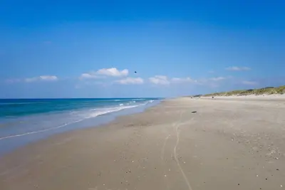 a sandy beach with the ocean in the background at Cozy house with stunning sea views in Pandrup