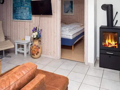 a room with a living room with a fireplace and a bed at 6 person holiday home in Hurup Thy in Sønder Ydby