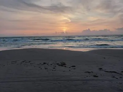 a sunset on a beach with the ocean at 6 person holiday home in Blokhus in Blokhus