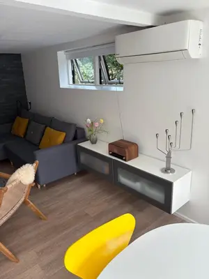 a living room with a blue couch and yellow chairs at Nyistandsat højloftet kælderlejlighed på 70 m2 i Viborg centrum, med plads til 4 personer in Viborg