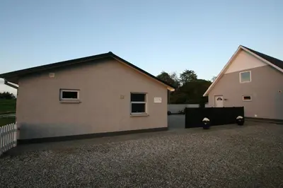 a house with two buildings next to a driveway at Hellerup Bed & Breakfast in Løgstrup