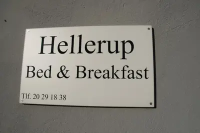 a sign for a bed and breakfast hanging on a wall at Hellerup Bed & Breakfast in Løgstrup