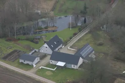 an aerial view of a house with a pond at Hellerup Bed & Breakfast in Løgstrup