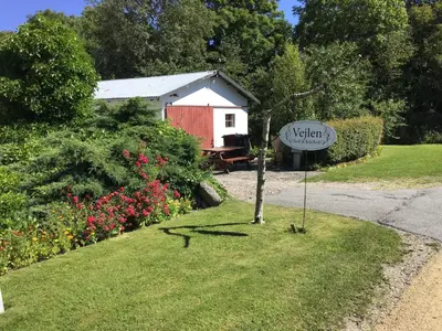 a sign in the grass next to a red shed at Vejlen Bed & Kitchen in Vadum