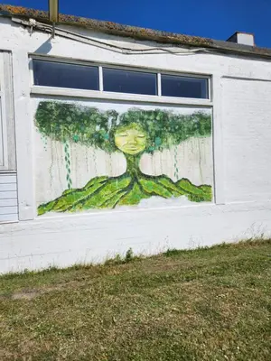a painting of a woman with a tree on the side of a building at Løgstør Camping in Løgstør