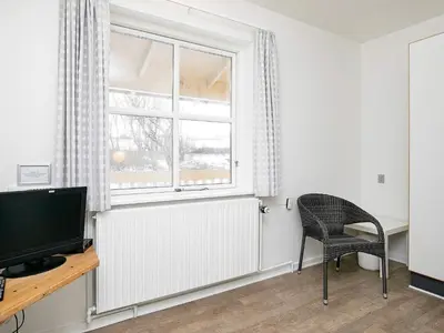a room with a radiator and a chair and a window at Room in a holiday park- Type4 in Hanstholm