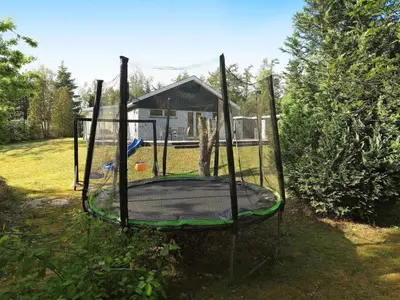 a trampoline in a yard with a playground at 6 person holiday home in Højslev-By Traum in Højslev