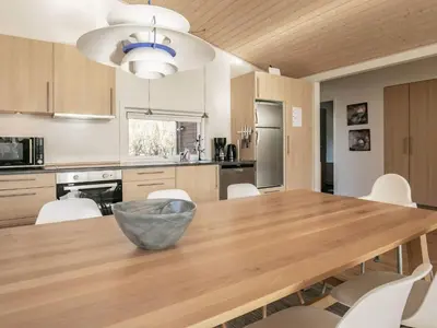 a kitchen with a wooden table and white chairs at 6 person holiday home in Vestervig-By Traum in Vestervig