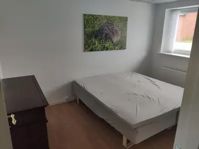 a small bedroom with a bed and a window at Ferielejlighed ved Vilsted Sø in Løgstør