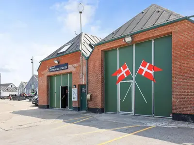 a brick building with two flags on the side of it at 10 person holiday home in Thisted in Thisted