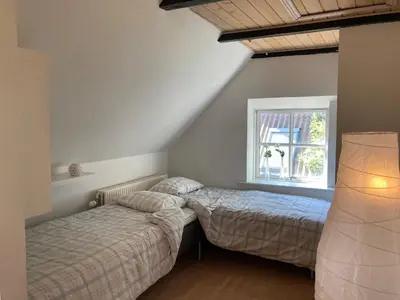 two beds in a bedroom with a window at Kallerup Hgård in Thisted