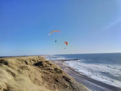 a person flying a kite over the beach at Rikke og Franks Svineri in Lemvig