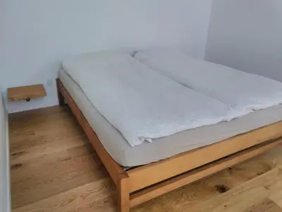 a bed sitting on a wooden platform in a room at Rikke og Franks Svineri in Lemvig