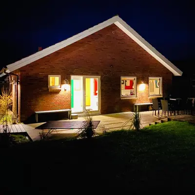 a brick house with a porch at night at Event4U in Nykøbing Mors