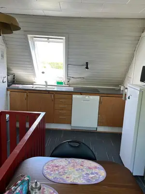 a small kitchen with a table and a refrigerator at Munkebo B&B, Thy in Thisted