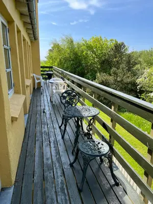 two benches sitting on a wooden deck on a house at Munkebo B&B, Thy in Thisted
