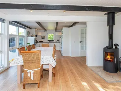 a dining room with a table and a fireplace at 6 person holiday home in Løgstør in Løgstør