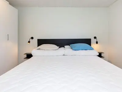a bedroom with a large white bed with two pillows at 6 person holiday home in Løgstør in Løgstør