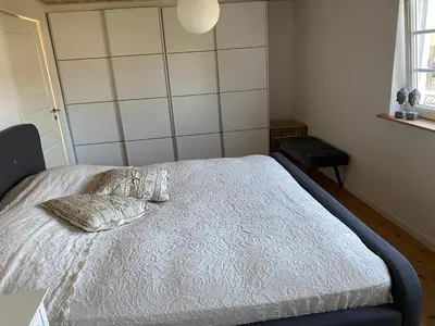 a bedroom with a bed with two pillows on it at A Vesterhav - tæt på 18b og hotel in Harboør