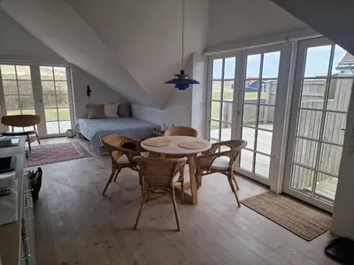 a living room with a table and chairs and a couch at Fiskerhuset in Agger