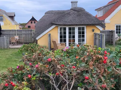 a small yellow house with a thatched roof at Fiskerhuset in Agger
