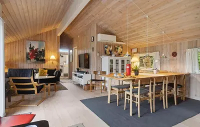 a kitchen and living room with a table and chairs at Holiday Home Odavej Løkken Xi in Løkken