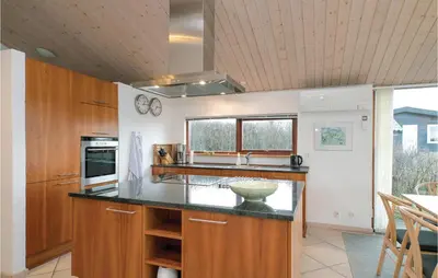 a kitchen with wooden cabinets and a counter top at Holiday Home Ruthsvej in Løkken