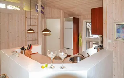 two wine glasses sitting on a counter in a kitchen at Holiday Home Sarasvej Løkken in Løkken