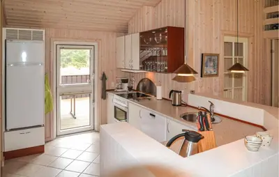 a kitchen with a sink and a refrigerator at Holiday Home Sarasvej Løkken in Løkken