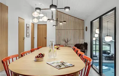 a dining room with a wooden table and chairs at Nice Home In Saltum With Kitchen in Saltum