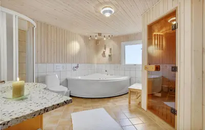 a bathroom with a tub and a toilet and a sink at Holiday Home Porsevej Saltum in Saltum
