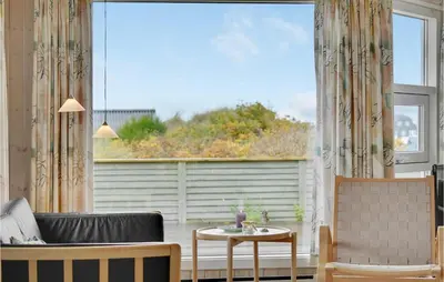 a living room with a couch and a large window at Holiday Home Porsevej Saltum in Saltum