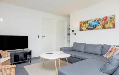 a living room with a couch and a table at Nice Home In Blokhus With Sauna in Blokhus
