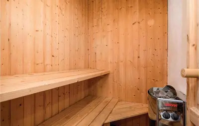 an empty wooden sauna with a trash can at Nice Home In Blokhus With Sauna in Blokhus