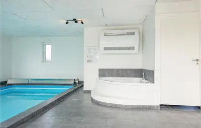 a bathroom with a swimming pool and a tub at Nice Home In Blokhus With Sauna in Blokhus