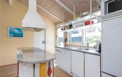 a kitchen with white cabinets and a counter top at Holiday Home Moreavej in Blokhus