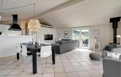 a dining room and living room with a table and chairs at Holiday Home Tobaksvej in Blokhus