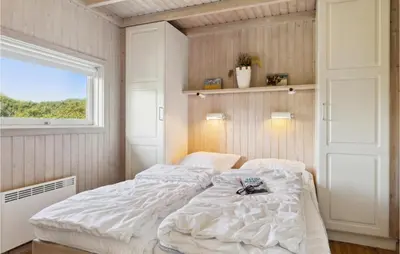 a bedroom with a large white bed with a window at Pet Friendly Home In Pandrup With Sauna in Pandrup