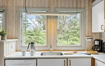 a kitchen with a sink and two windows at Holiday Home Østersvej Fjerritslev Xii in Fjerritslev