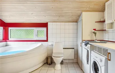 a bathroom with a tub and a toilet and a sink at Holiday Home Harestien Brovst in Brovst