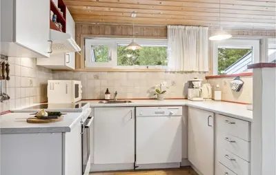 a kitchen with white cabinets and white appliances at Holiday Home Harestien Brovst in Brovst