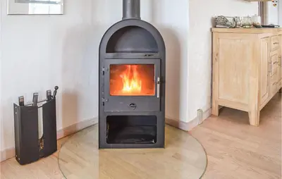 a wood stove in a room with a fireplace at Holiday Home Themisvej Harboøre Xii in Harboør