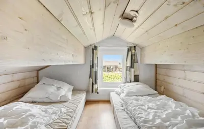 two beds in a room with a window at Holiday Home Vejlby Klit in Harboør