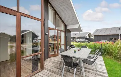 a wooden deck with a table and chairs on it at Holiday Home Klitengene Ulfborg Vi in Ulfborg