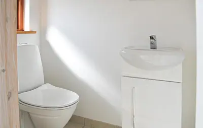 a bathroom with a white toilet and a sink at Holiday Home Klitengene Xi in Ulfborg