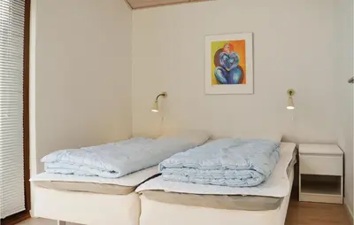 two white beds in a room with a picture on the wall at Holiday Home Klitengene Xi in Ulfborg