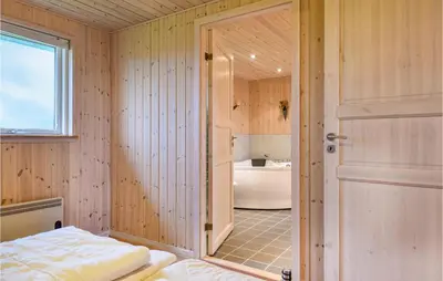 a bathroom with a bed and a tub and a door at Holiday Home Bjergehusvej in Harboør