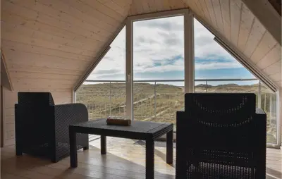 a room with two chairs and a table in front of a window at Holiday Home Doblervej Harboøre X in Harboør