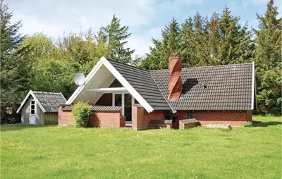 a brick house with a chimney on top of a yard at Humlebo in Vemb